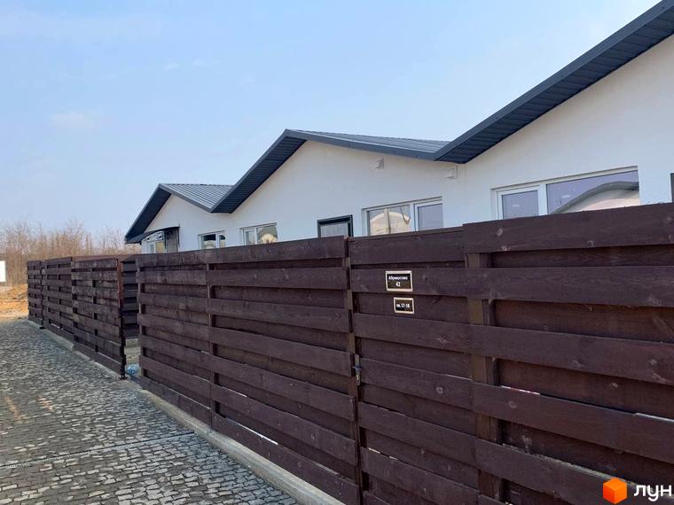 Таунхаус „Белгород“: сучасні будинки з дерев'яним парканом та бруківкою на території.