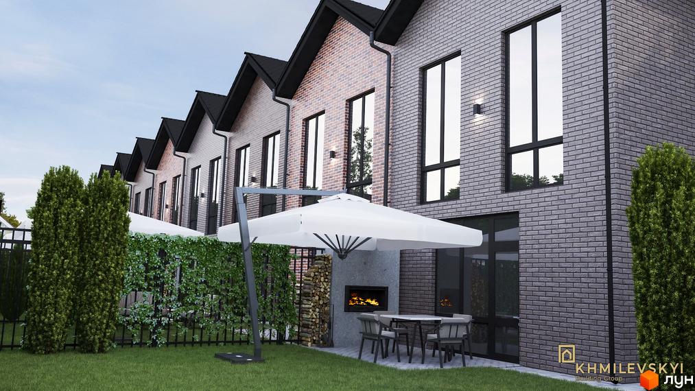 Таунхауси V8 townhouse з цегляним фасадом та великими вікнами, з прибудинковою територією з парасолькою, каміном та зеленню.