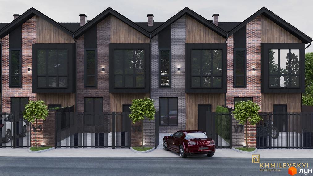 Таунхауси V8 townhouse - сучасний житловий комплекс з цегляним фасадом та великими вікнами. На прибудинковій території розташовані дерева та паркан.