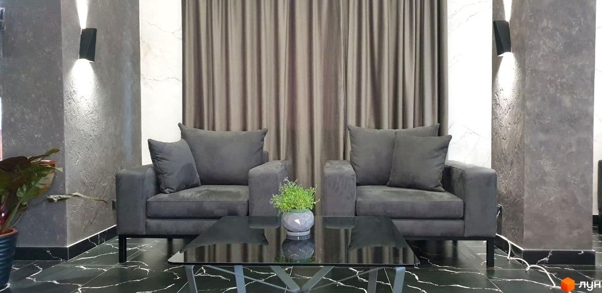 Затишна зона відпочинку в ЖК Зелений замок з двома сірими кріслами та журнальним столиком. Сучасний дизайн інтер'єру.