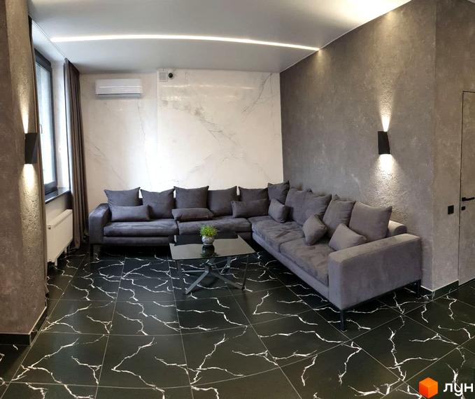 Вітальня з сірим кутовим диваном, кавовим столиком та чорною підлогою з білим візерунком. Сучасний дизайн інтер'єру новобудови ЖК Зелений замок.