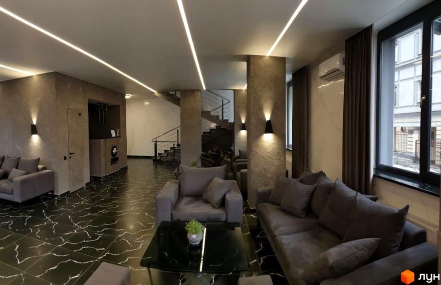 Інтер'єр холу житлового комплексу Зелений замок з диванами та кавовим столиком. Сучасний дизайн та оздоблення стін.