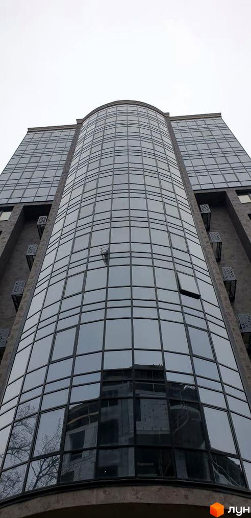 Фасад житлового комплексу Зелений замок з панорамним склінням. Зовнішній вигляд новобудови з вигнутими лініями.