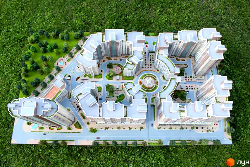 Макет Житлового комплексу Французький квартал з багатоповерховими будинками та розвиненою прибудинковою територією, що включає зелені зони, дитячі майданчики та тенісний корт.