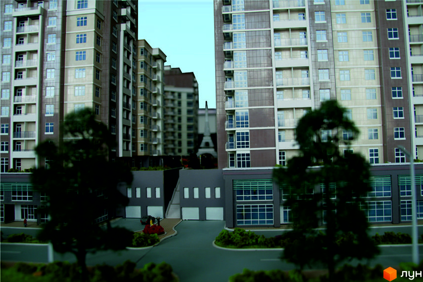 Багатоповерхові будинки Житлового комплексу Французький квартал з вікнами та балконами. На передньому плані видно прибудинкову територію з деревами та дорогами.