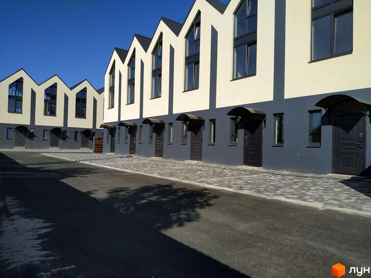 Таунхауси „На Дачній“ – двоповерхові будинки з двосхилими дахами та великими вікнами, розташовані вздовж вимощеної бруківкою алеї.