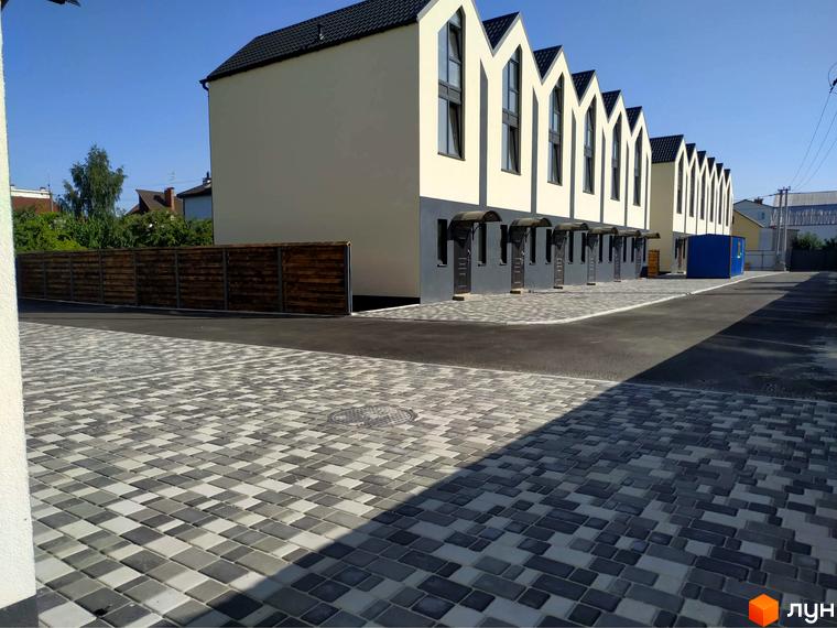 Таунхауси „На Дачній“ – це двоповерхові будинки з гострокутними дахами та індивідуальними входами, розташовані на вимощеній бруківкою прибудинковій території.