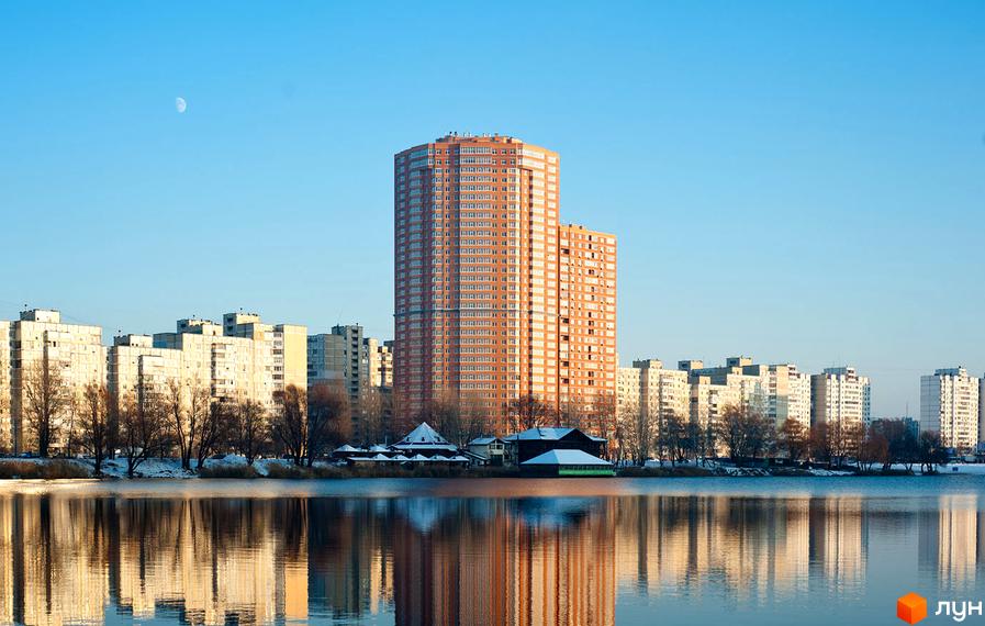 Житловий комплекс Ревуцького, 9, з висотним будинком та прибудинковою територією біля водойми.