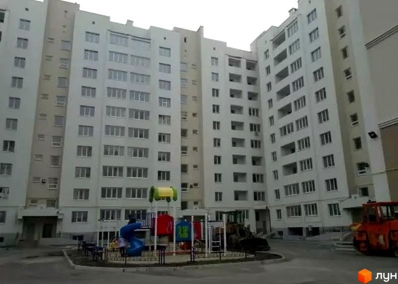 Зовнішній вигляд багатоповерхових будинків житлового комплексу на вулиці Бреуса, 61/9. На прибудинковій території розташований дитячий майданчик та будівельна техніка.