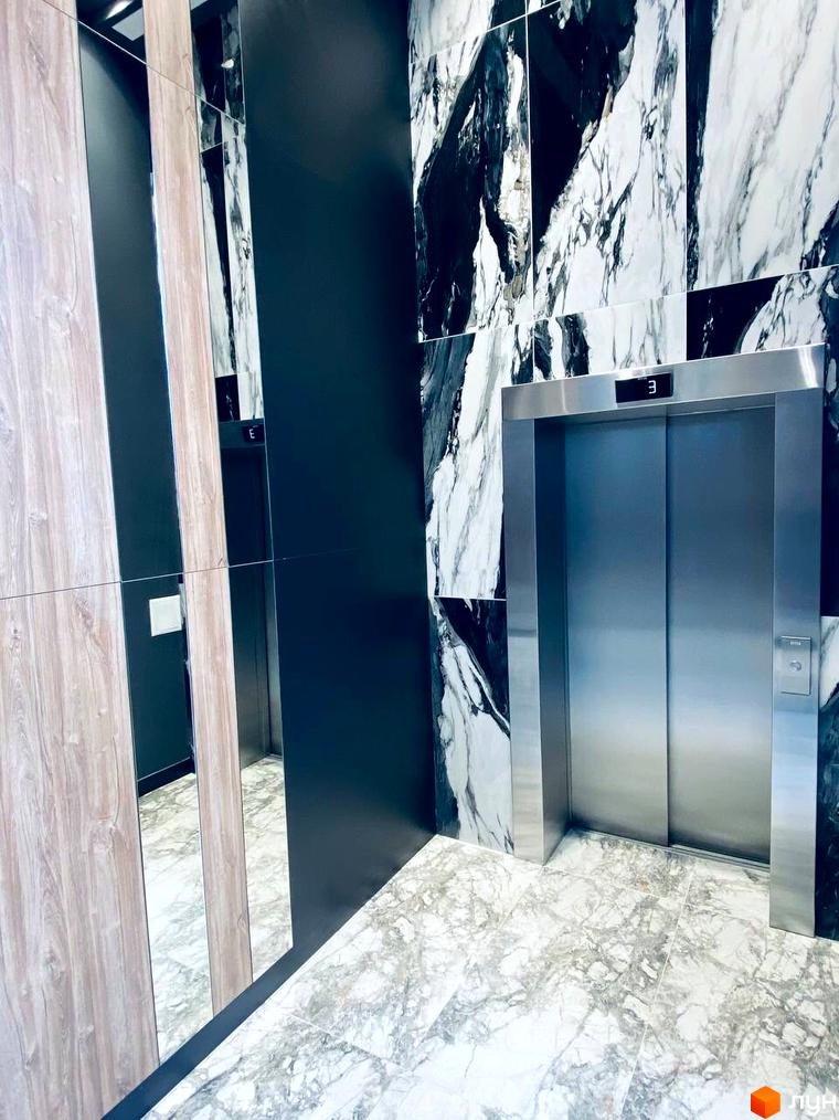 Інтер'єр ліфтового холу Житлового комплексу CENTRAL HOUSE з оздобленням мармуром, дзеркалами та дерев'яними панелями.