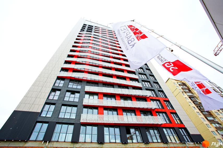 Житловий комплекс Квартет – висотна новобудова з червоно-сірим фасадом та панорамними вікнами. Зовнішній вигляд будівлі вражає своїм сучасним дизайном та яскравими акцентами.