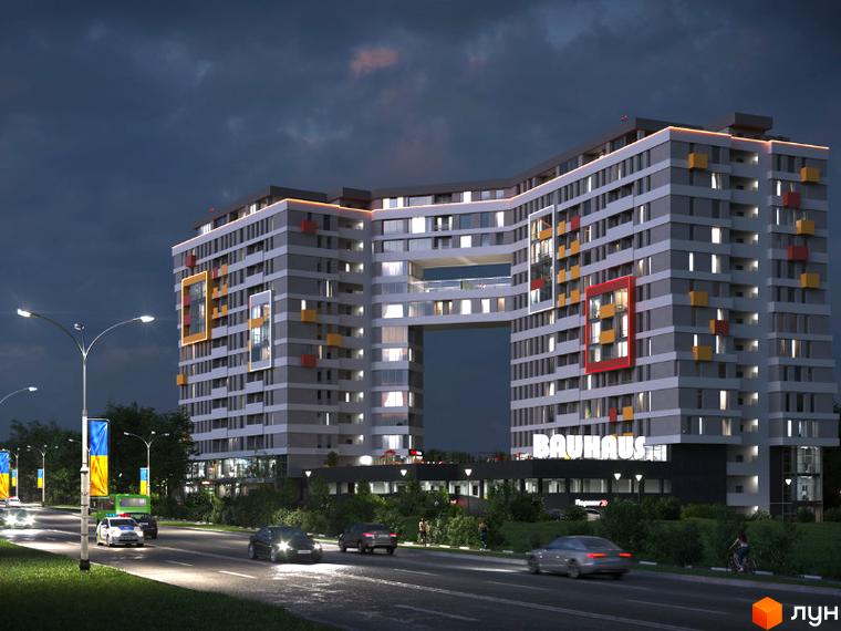 Житловий комплекс Bauhaus з унікальною архітектурою та підсвіткою фасаду ввечері. Навколо комплексу розташована дорога з автомобілями та вуличним освітленням.