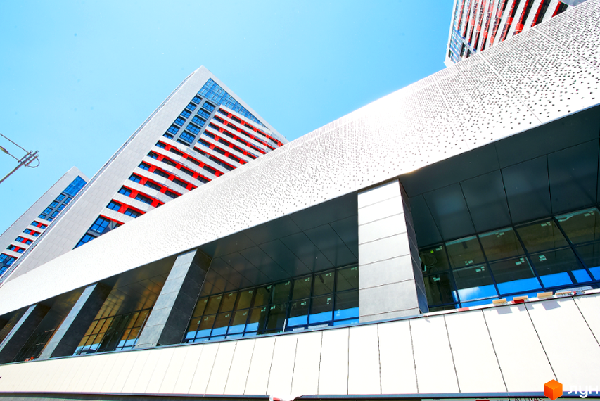 Зовнішній вигляд житлового комплексу Квартет з червоними та білими елементами фасаду та великими вікнами. Сучасна архітектура новобудови.