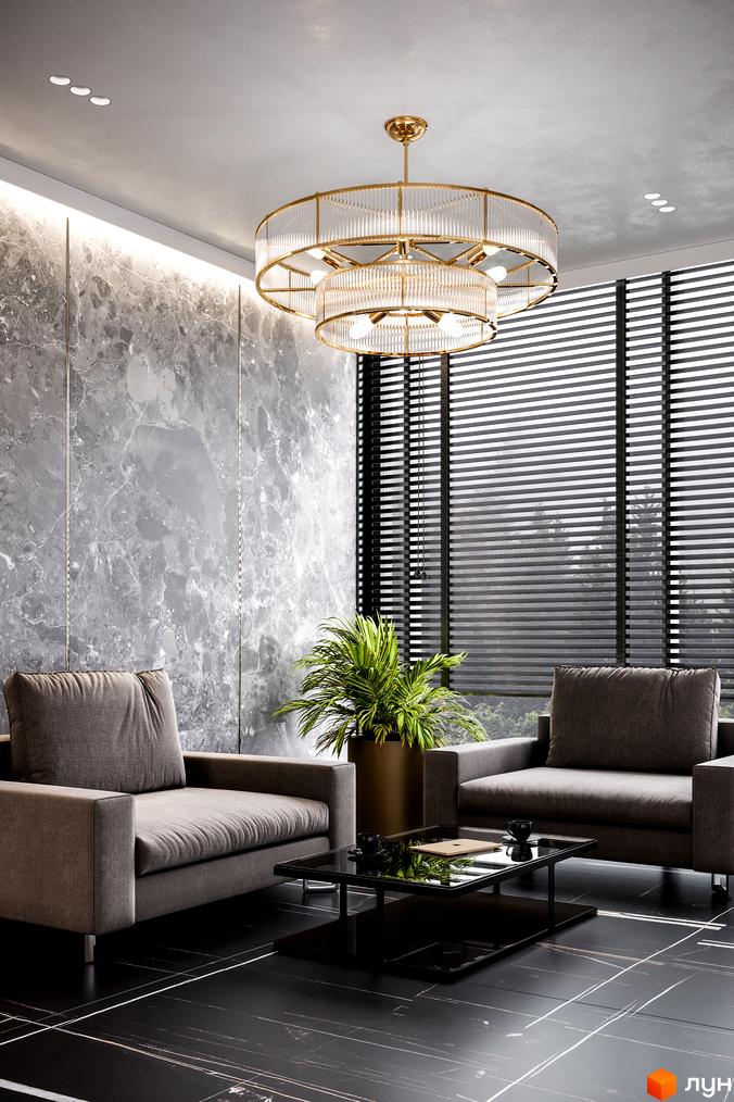 Інтер'єр вітальні в житловому комплексі Rusaniv Residence з сірими диванами, мармуровою стіною та великим круглим світильником.