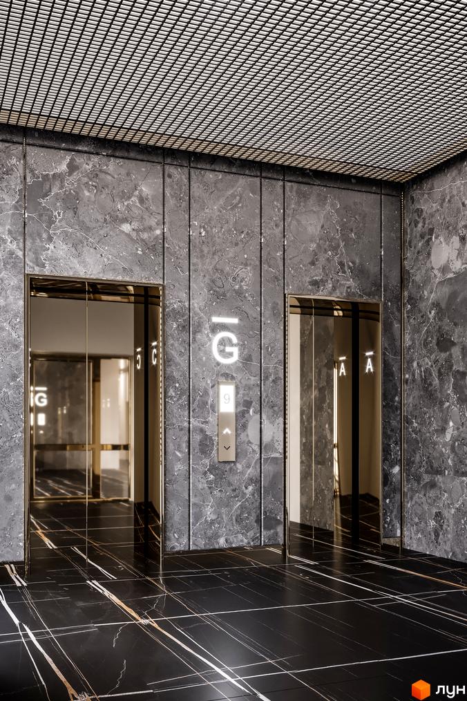 Інтер'єр ліфтового холу в Житловому районі Rusaniv Residence з двома ліфтами та мармуровим оздобленням стін і підлоги.