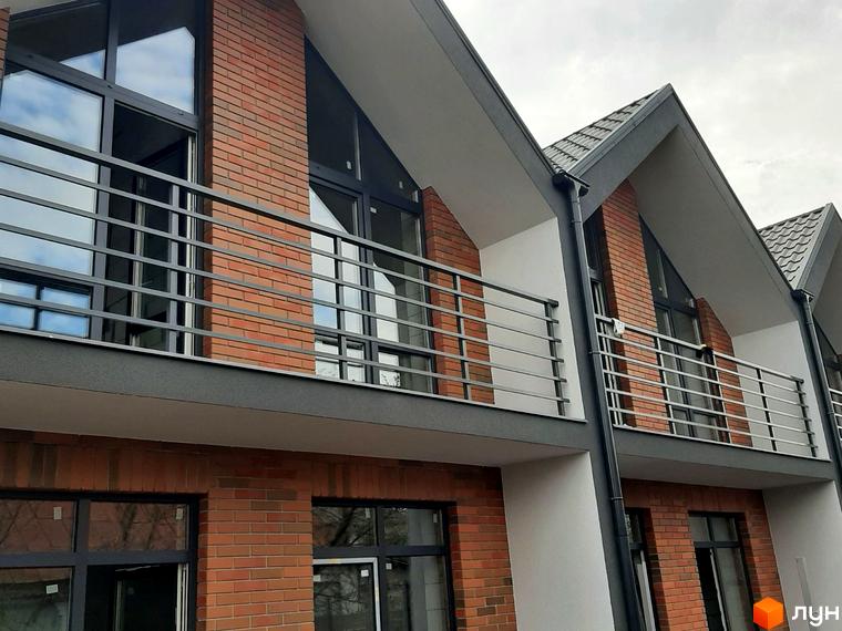 Таунхауси Nordic - фасади з цегли та великі вікна з балконами. Зовнішній вигляд новобудови з похилим дахом.