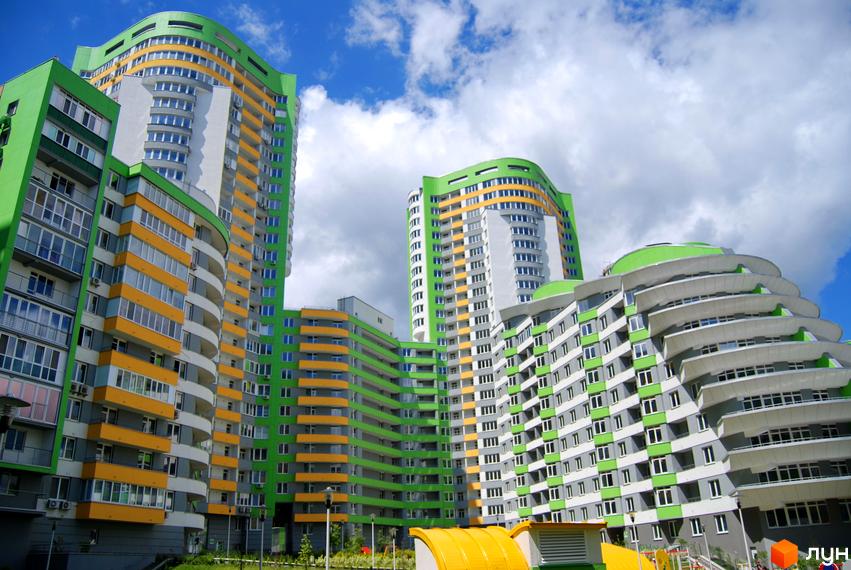 Житловий комплекс Паркове місто: багатоповерхові будинки з яскравими зеленими та жовтими фасадами, вигнутими лініями. Навколо облаштована зелена територія.