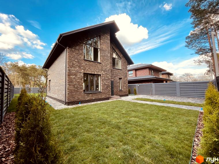Котеджне містечко КМ Лісова Білогородка: цегляний будинок з великими вікнами та доглянутою зеленою прибудинковою територією.