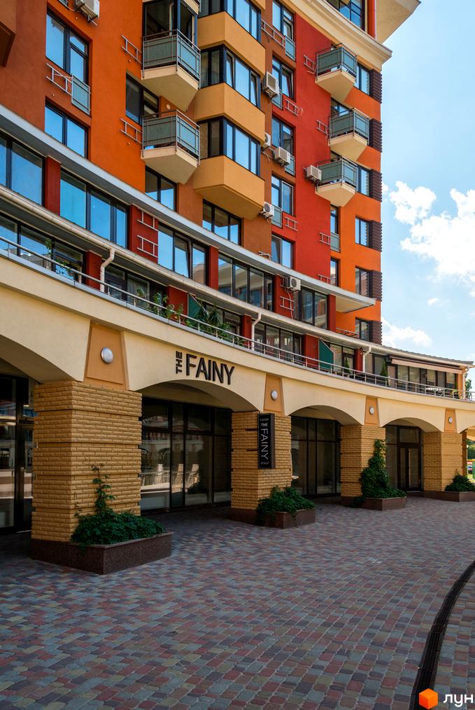 Житловий комплекс Сонячна брама з яскравим фасадом та балконами. Прибудинкова територія викладена плиткою з зеленими насадженнями.