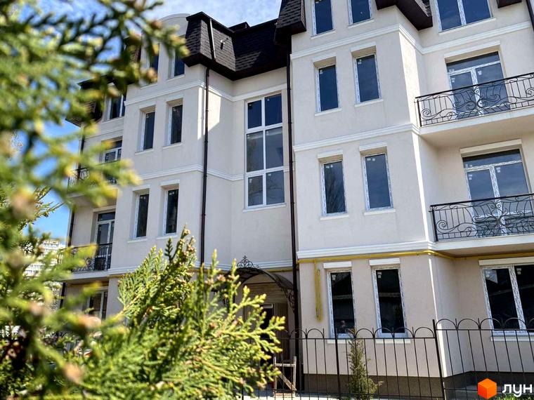Зовнішній вигляд будинку Житловий комплекс по вул. Академіка Вернадського (Тульська), 21а з балконами та кованими огорожами, поруч зелені насадження.