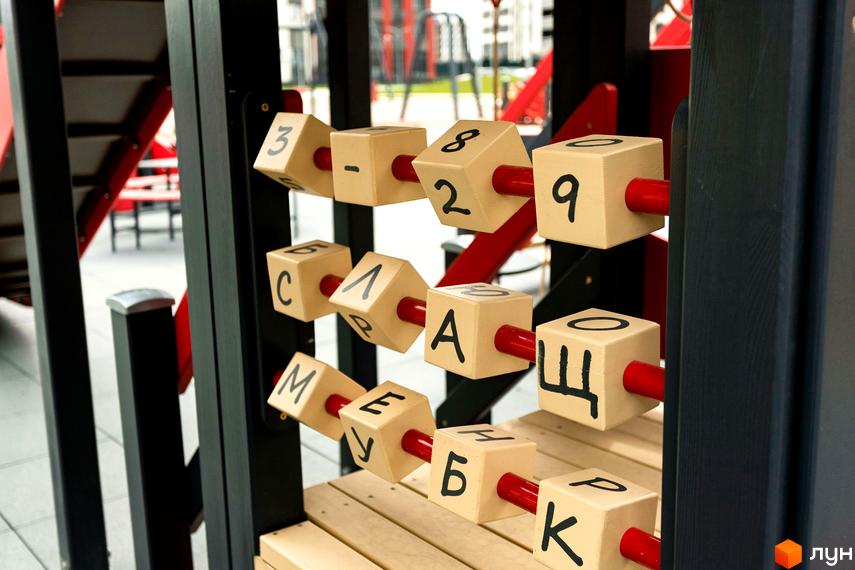 Житловий комплекс Варшавський Плюс: дитячий майданчик з кубиками з літерами та цифрами. Зовнішній вигляд новобудови та прибудинкова територія.