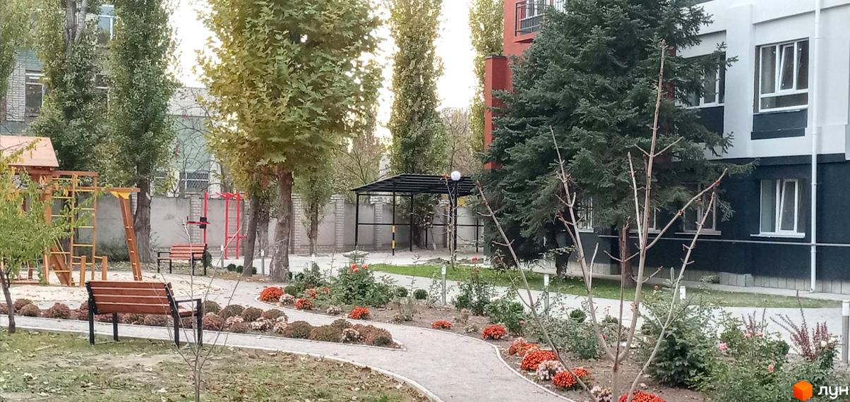 Житловий комплекс Парк Стоун з дитячим майданчиком та зонами відпочинку. Сучасна архітектура будівель та зелена прибудинкова територія.