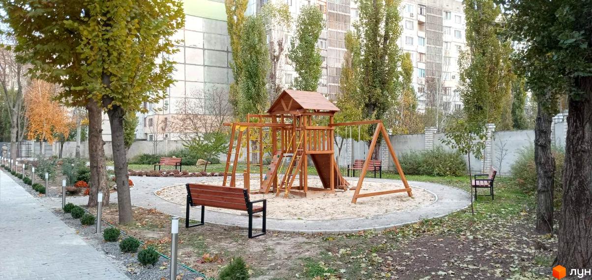 Житловий комплекс Парк Стоун: дитячий майданчик з гіркою та гойдалками, лавки та доріжки на прибудинковій території.