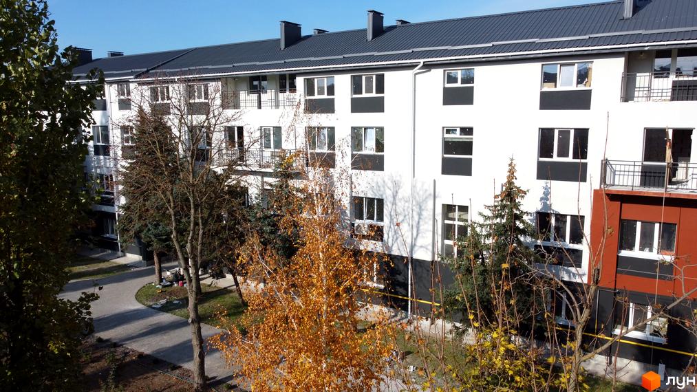 Зовнішній вигляд новобудови ЖК Парк Стоун з вікнами та балконами, оточеної деревами та доглянутою прибудинковою територією.