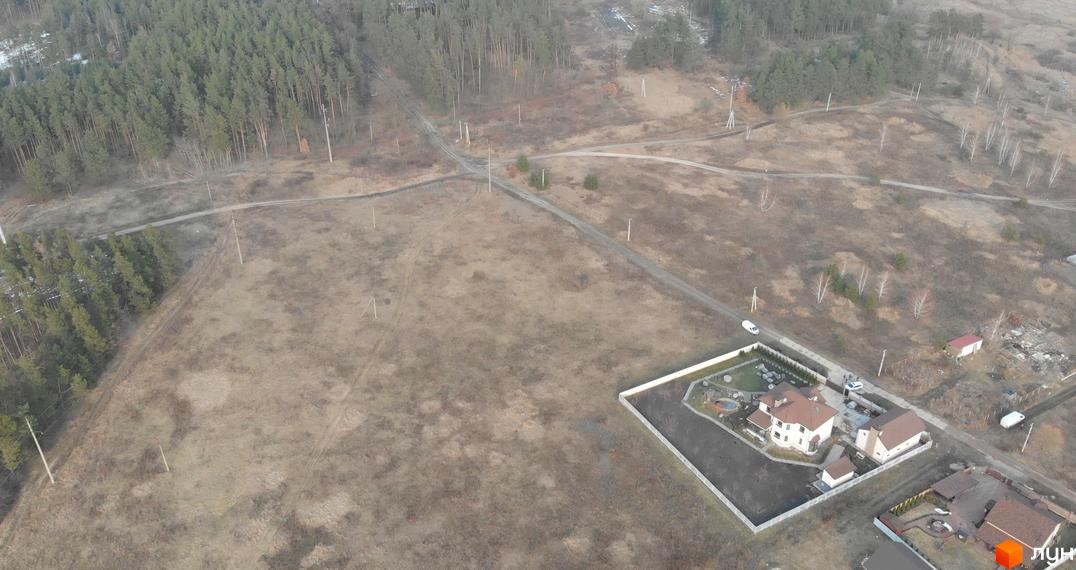 Вид зверху на котеджний комплекс КМ Хутір Демидово. Будинки з коричневими дахами та білими стінами, розташовані на території з ландшафтним дизайном.