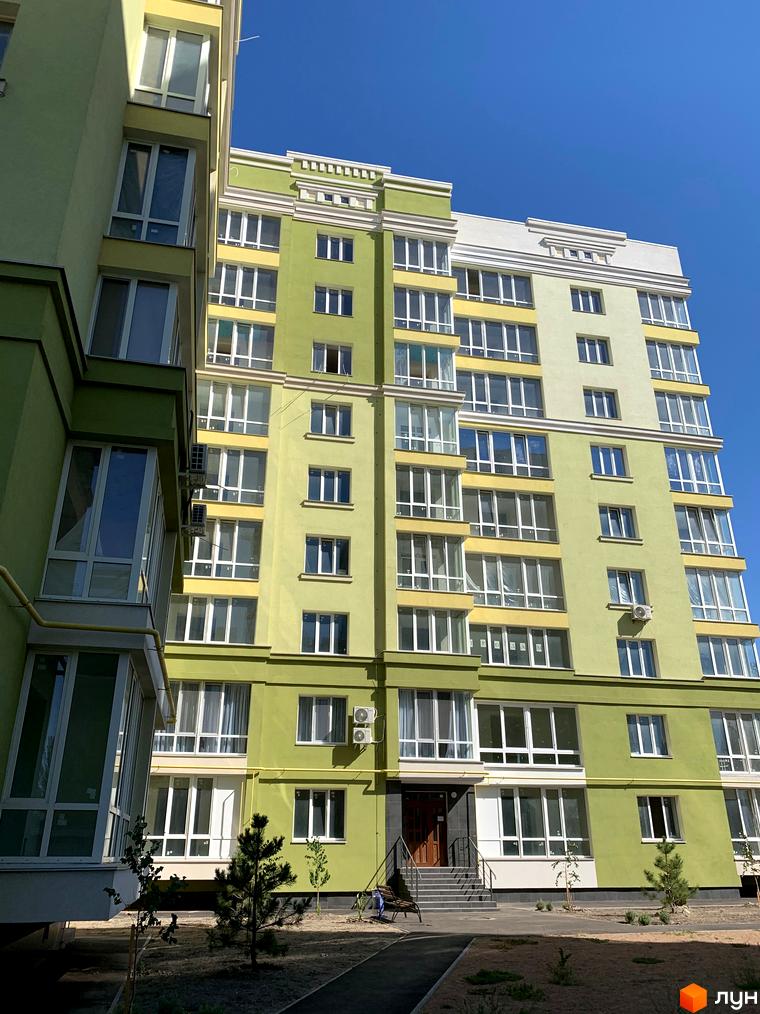 Зображення фасаду багатоповерхового будинку в Житловому комплексі Levanevsky. Вигляд будівлі та прибудинкової території з озелененням.
