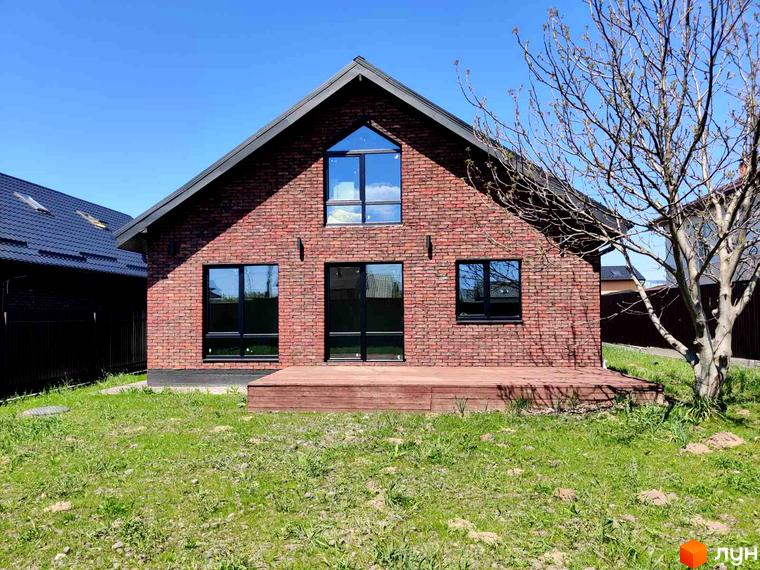 Котеджне містечко КМ Одноповерховий Київ - Мархалівка. Цегляний будинок з великими вікнами та дерев'яною терасою на тлі зеленого газону та блакитного неба.