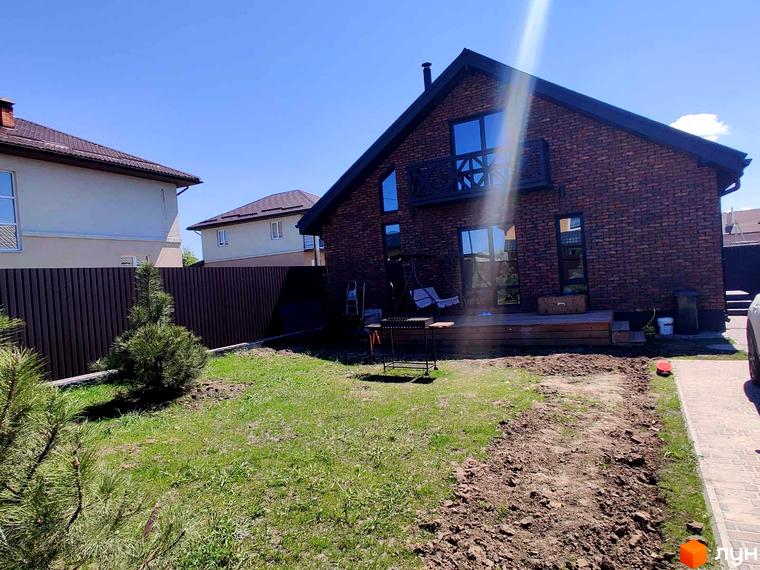 Котеджне містечко Одноповерховий Київ - Мархалівка: двоповерховий цегляний будинок з терасою та зеленим газоном.