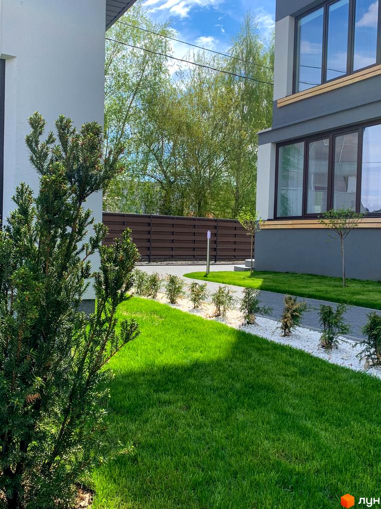 Зовнішній вигляд будинку в Житловому комплексі Cофія. Навколо будинку зелений газон, декоративні кущі та доріжки.