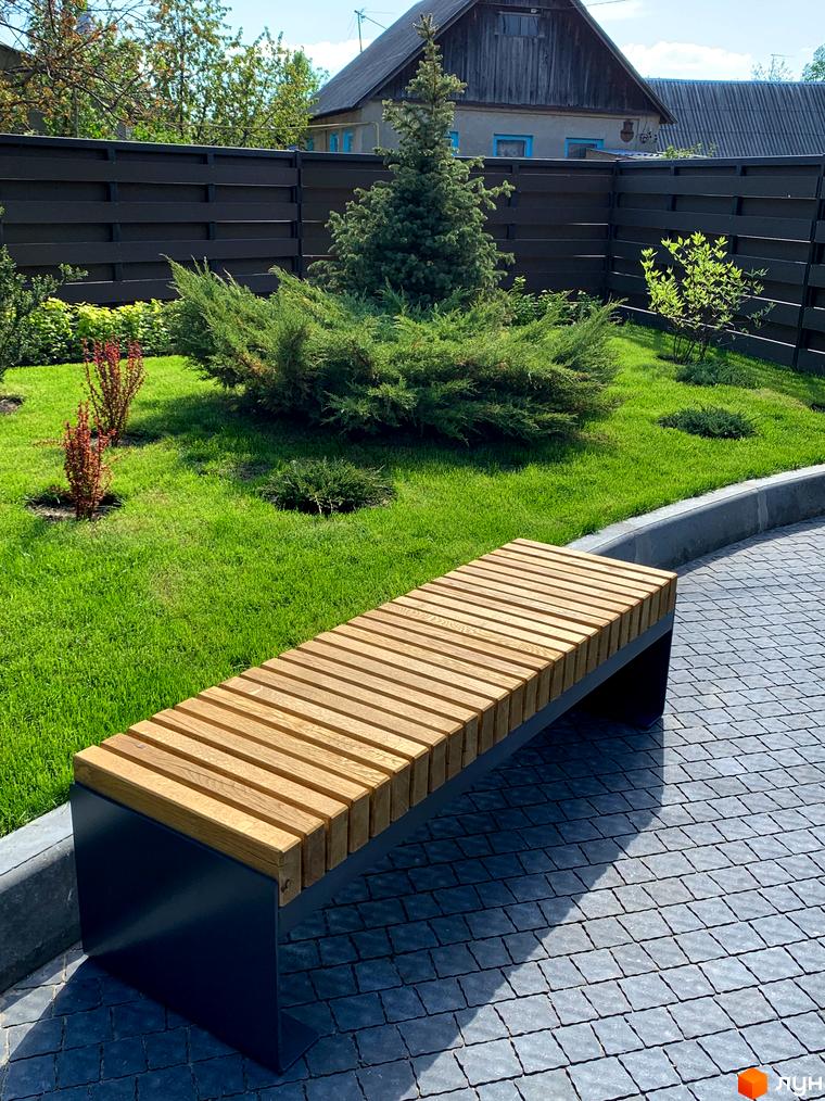 Житловий комплекс Софія з фасадом з дерева та доглянутою прибудинковою територією з газоном, кущами та лавкою для відпочинку.