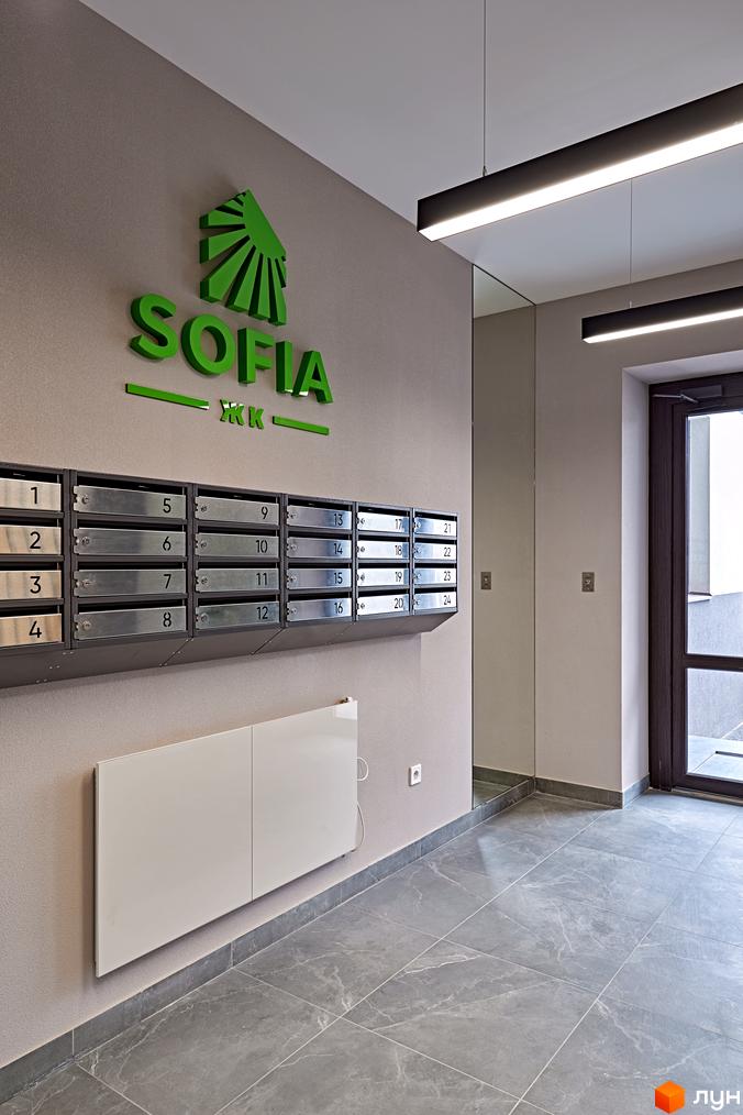 Інтер'єр вхідної групи Житлового комплексу Sofia з поштовими скриньками та освітленням. Плитка на підлозі сірого кольору.
