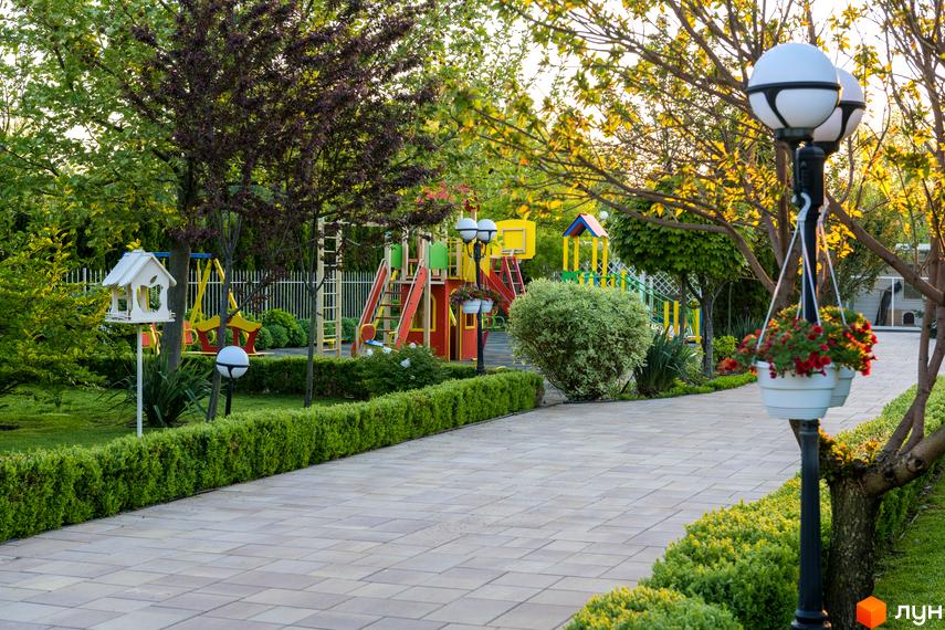 Благоустрій Котеджного містечка Золоче Прованс: доглянута територія з дитячим майданчиком та освітленою пішохідною зоною.
