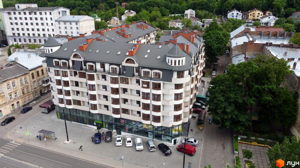 Житловий комплекс Львівський дворик - сучасна новобудова з багатоповерховими будинками та балконами. Навколо комплексу розташовані дерева та міська забудова.