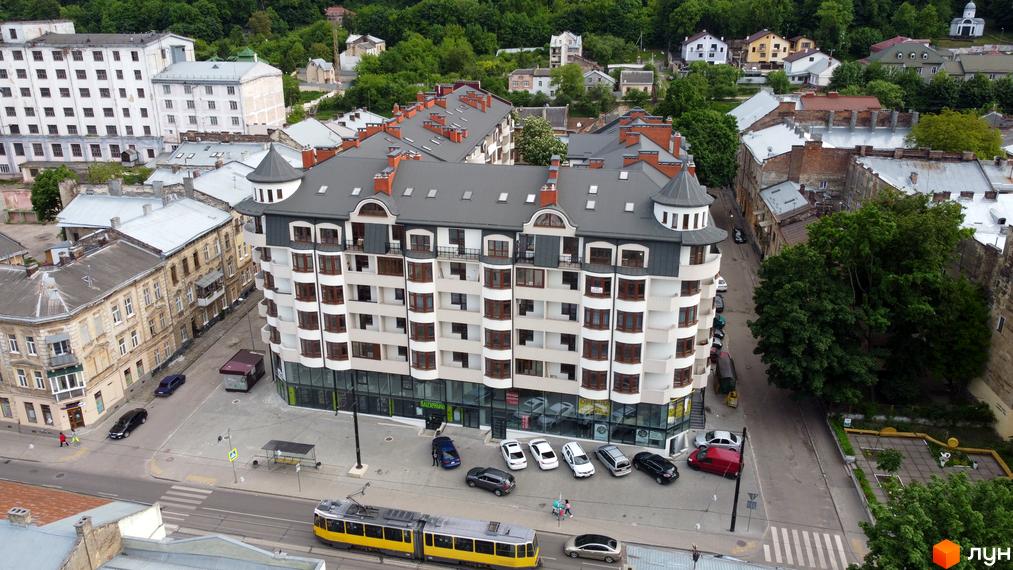 Сучасний житловий комплекс Львівський дворик з багатоповерховими будинками та прибудинковою територією з трамвайною лінією.