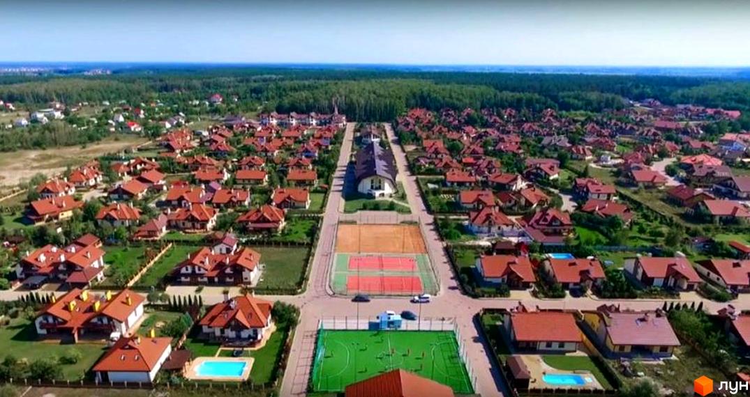 Вид на Котеджне містечко Северинівка з повітря: будинки з коричневими дахами, доглянуті газони та спортивні майданчики.