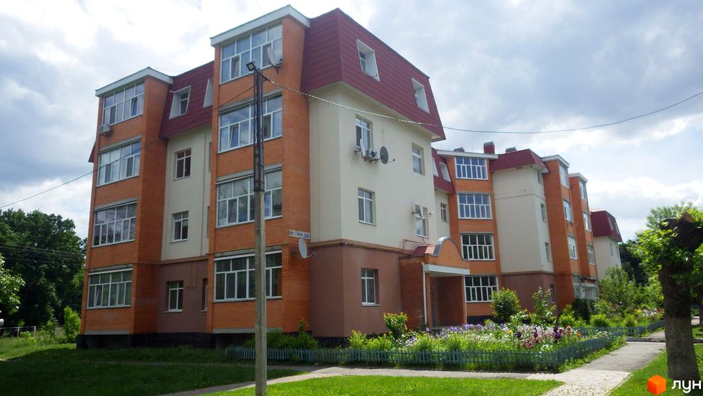 Будинок житлового комплексу на вул. Гайок, 224б, з цегляним фасадом та червоним дахом, оточений зеленим газоном та квітником.