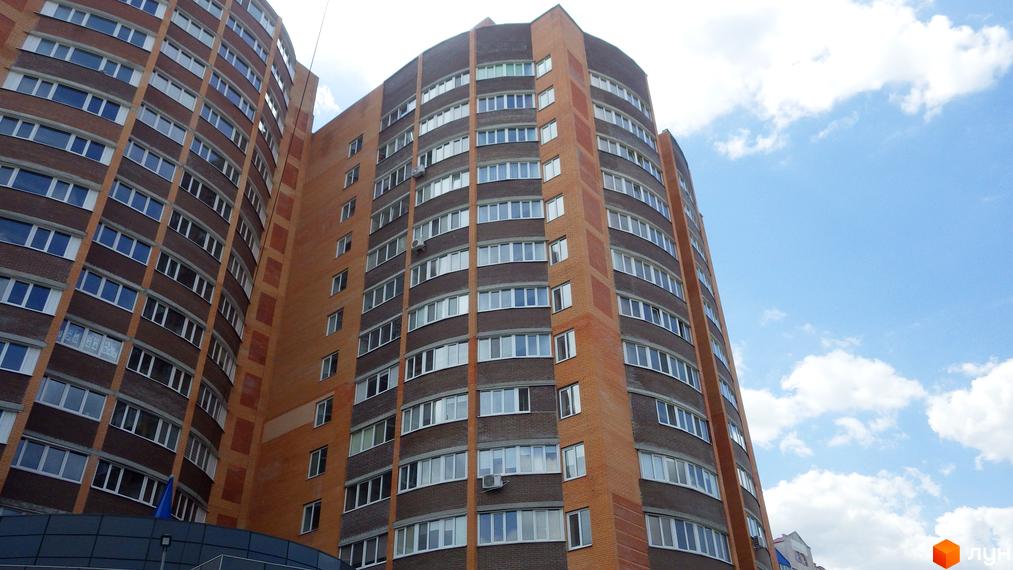 Вид на багатоповерховий житловий комплекс на вул. Леваневського, 70. Будинок має вигнутий фасад з цегляним оздобленням та численними вікнами.