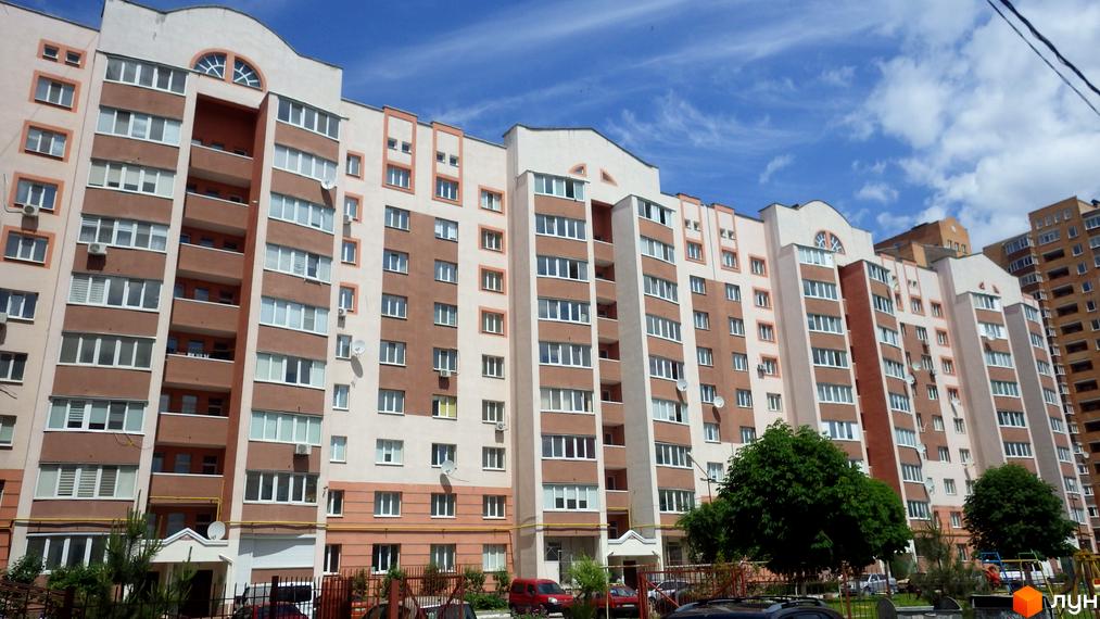 Зовнішній вигляд багатоповерхового житлового комплексу на вул. Леваневського, 70. Навколо будинку розташовані дерева та дитячий майданчик.