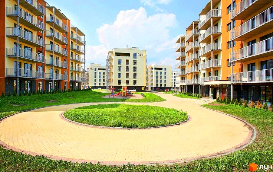 Житловий комплекс Ліпінка: багатоповерхові будинки кремового та помаранчевого кольорів з балконами. Прибудинкова територія включає зелені газони, вимощені доріжки та дитячий майданчик.