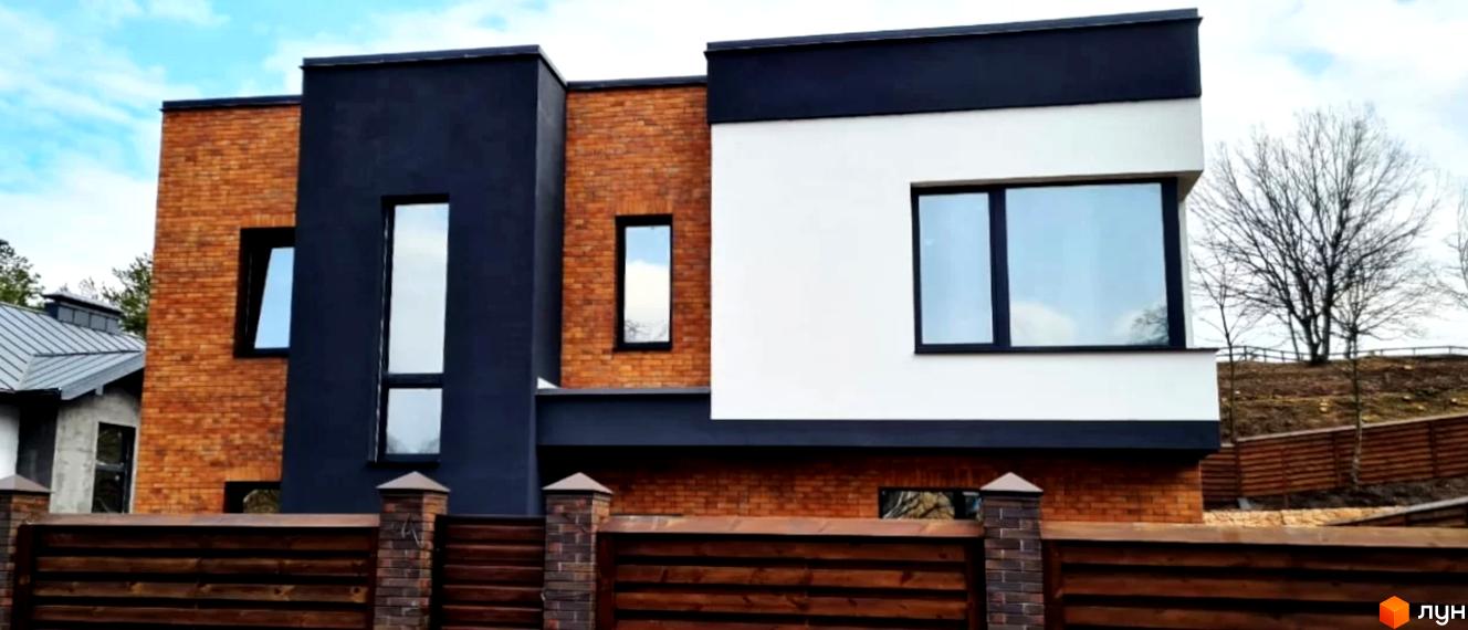 Котеджне містечко КМ Сонячний схил: двоповерховий будинок з цегляним та білим фасадами, великими вікнами та дерев'яним парканом.