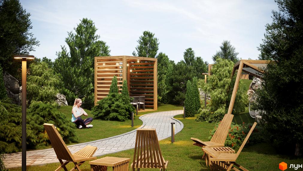 Котеджне містечко КМ Затишний: зелена зона з перголою, доріжками та місцями для відпочинку. Жінка медитує на траві.