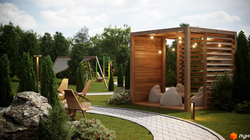 Прибудинкова територія Котеджного містечка Затишний: дерев'яна пергола з кріслами, вимощені доріжки, зелені насадження та дитячий майданчик.