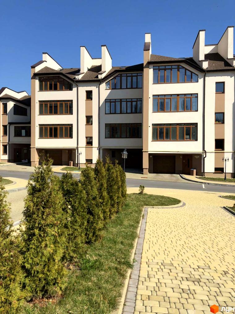 Житловий комплекс на вул. Паневежиська (Пугачова), 2. Зовнішній вигляд будівель з коричневими вікнами та коричневими елементами фасаду, прибудинкова територія з бруківкою та туями.