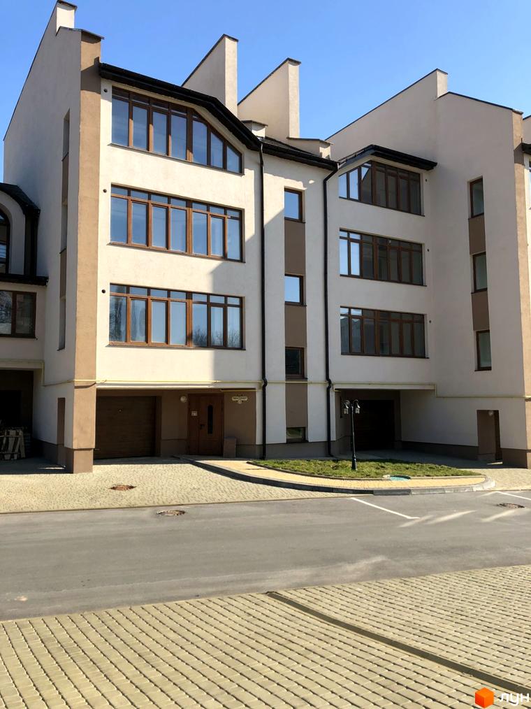 Зовнішній вигляд будинку житлового комплексу на вул. Паневежиська (Пугачова), 2, з прибудинковою територією та дорогою.