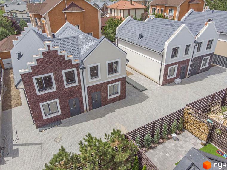 Дуплекси Lucky Home – двоповерхові будинки з цегляним фасадом та сірим дахом, розташовані на брукованій прибудинковій території з парканом та зеленими насадженнями.