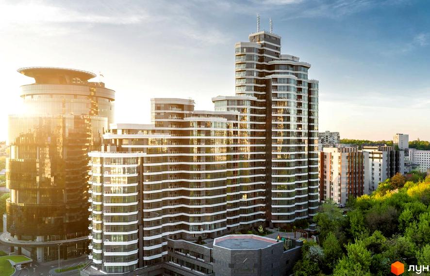 Житловий комплекс PecherSKY з багатоповерховими будинками, що мають терасовану структуру та численні балкони. Навколо комплексу розташовані зелені насадження.